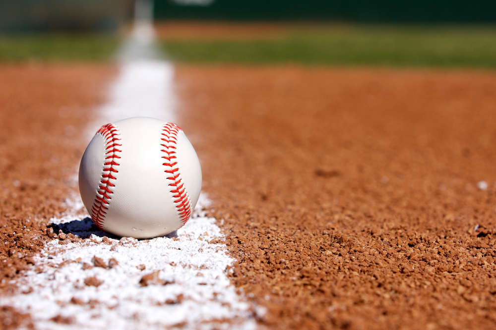 Baseball resting on the foul line at home plate