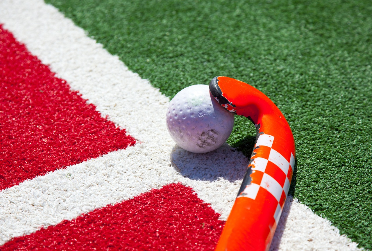 Field hockey stick and ball on the turf