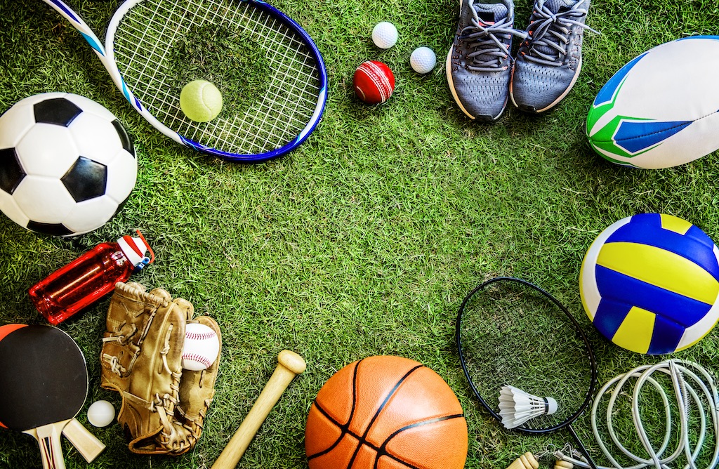Assorted sports equipment laid out on grass